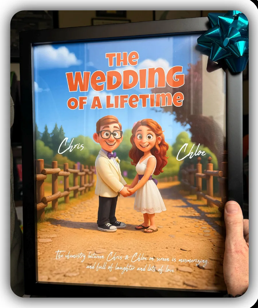 A hand holding a black-framed illustrated print titled The Wedding of a Lifetime, showing a cartoon couple named Chris and Chloe on a country path, with a teal gift bow stuck to the corner.
